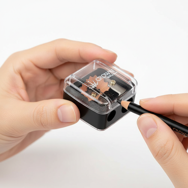 Hands using Crown Pro Dual Pencil Sharpener SHP01 to sharpen eyeliner pencil showing dual openings