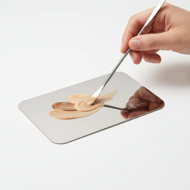 Professional makeup artist using Crown Stainless Steel Mixing Plate and Spatula Combo MCMB1 to blend makeup